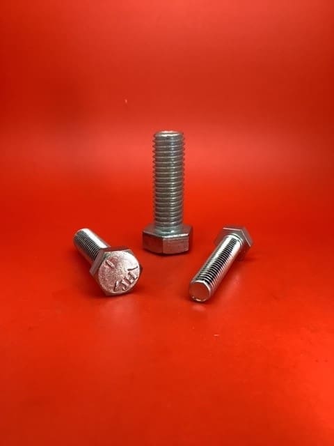 A group of three bolts sitting on top of a red table.