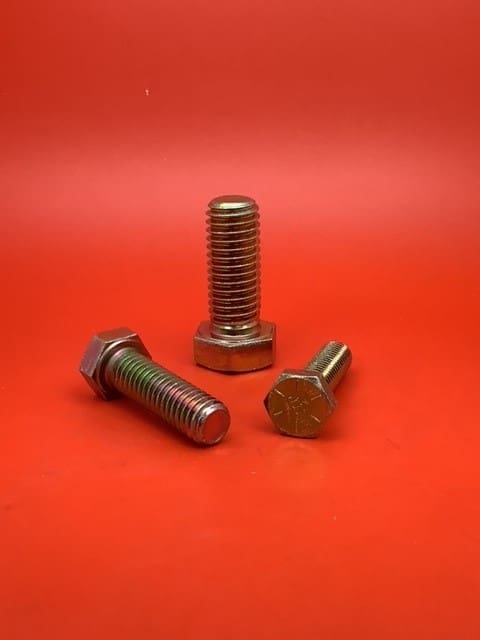 A group of three bolts sitting on top of a red surface.