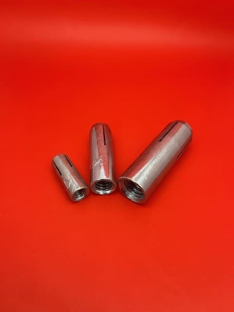 A group of three metal tubes on top of a red surface.