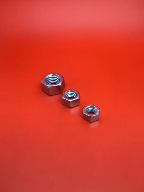 A group of three nuts sitting on top of a red table.