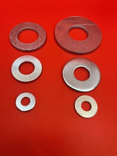 A group of washers on top of a red surface.