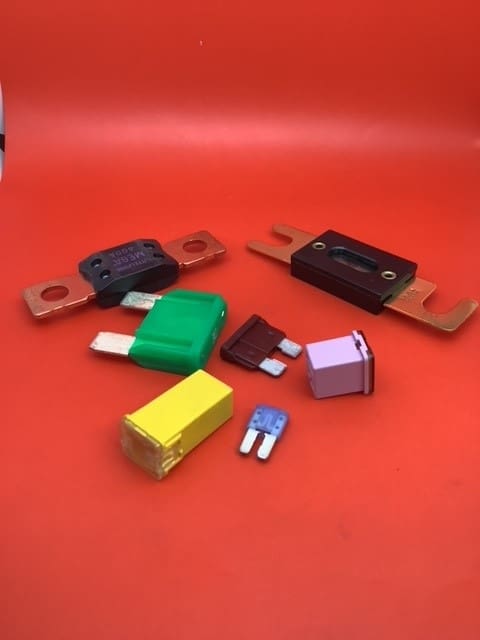 A group of different types of fuses on top of a red table.