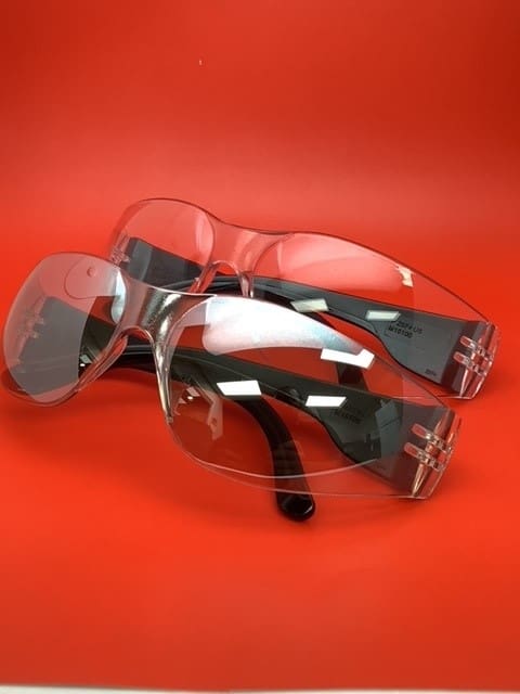 Two pairs of glasses are shown on a red surface.