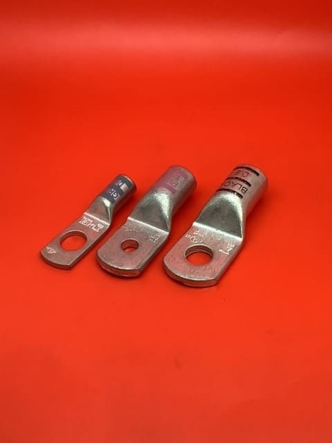 A group of three metal connectors sitting on top of a red surface.