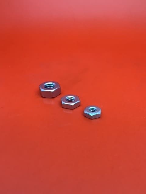 A group of three nuts sitting on top of a red surface.