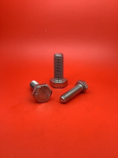 A group of three bolts sitting on top of a red surface.