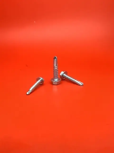 A group of three metal bolts sitting on top of a red table.