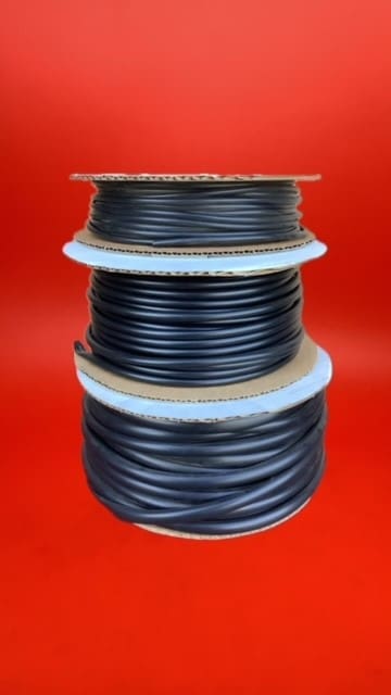 A stack of three rolls of black tubing.