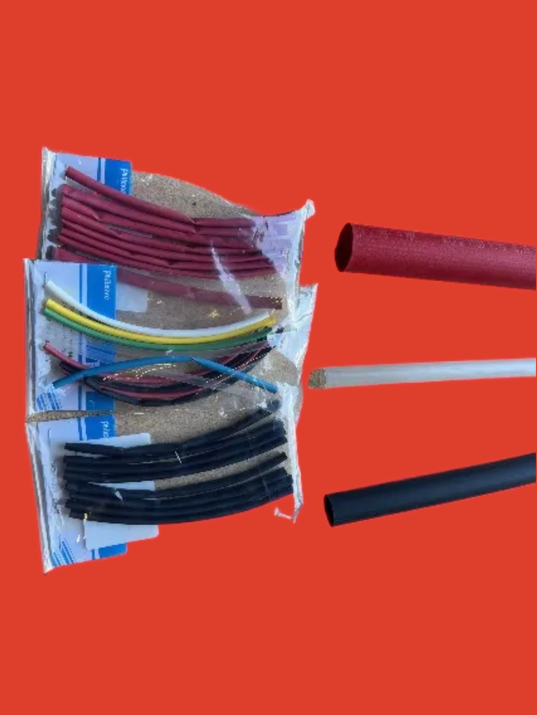 A red background with three different colored tubes of cable.