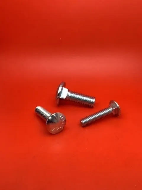 A group of three bolts sitting on top of a red table.