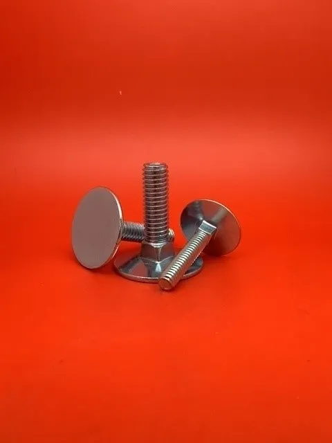 A pair of metal knobs sitting on top of a red table.