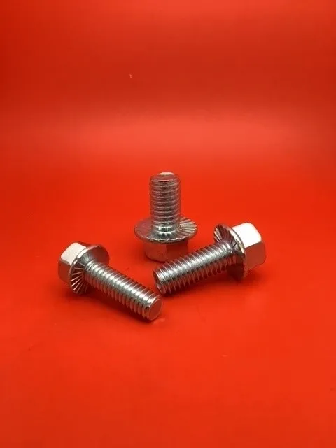 A pair of nuts and bolts on top of a red surface.