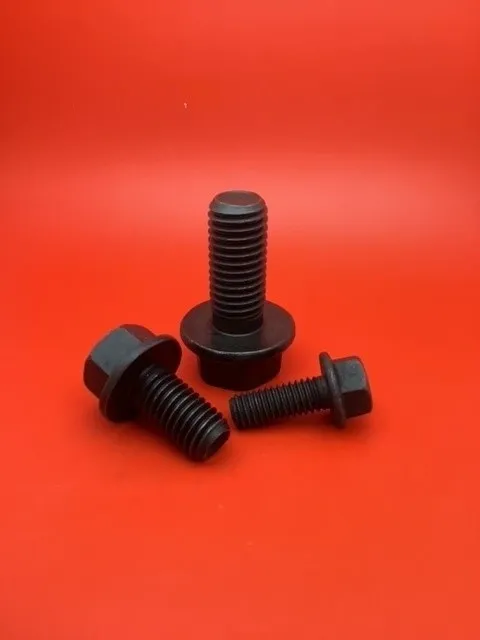 A group of three black bolts sitting on top of a red table.