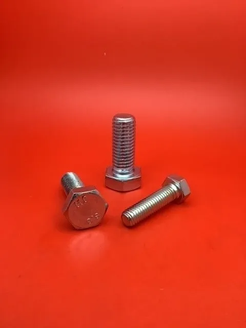 A group of three bolts sitting on top of a red table.