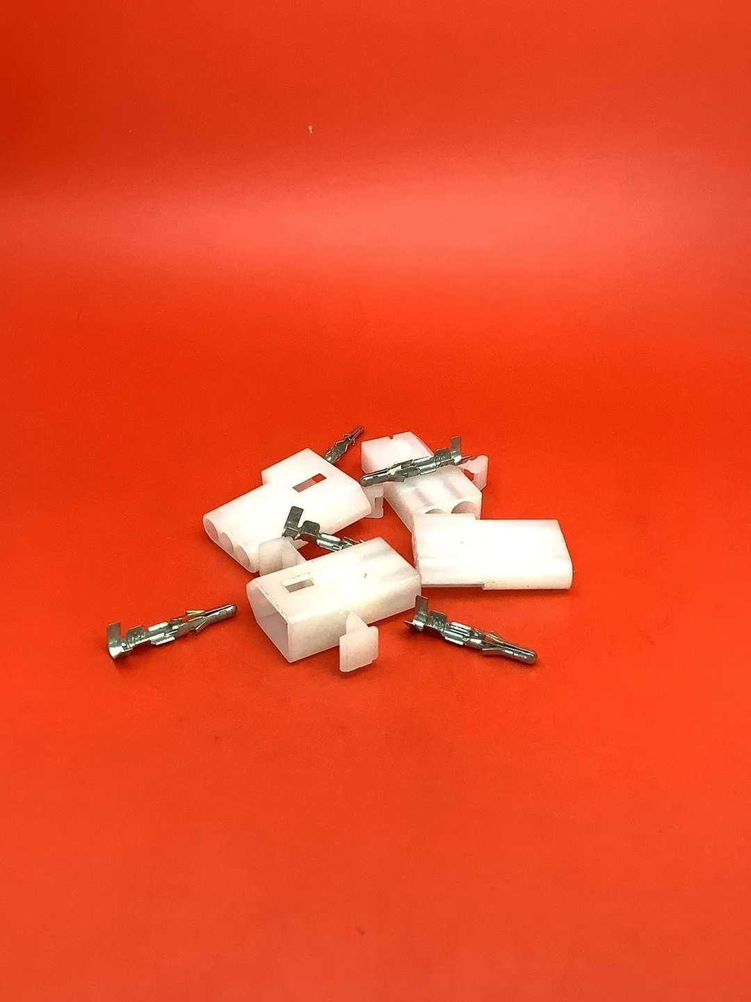 A group of white electrical plugs sitting on top of a red table.