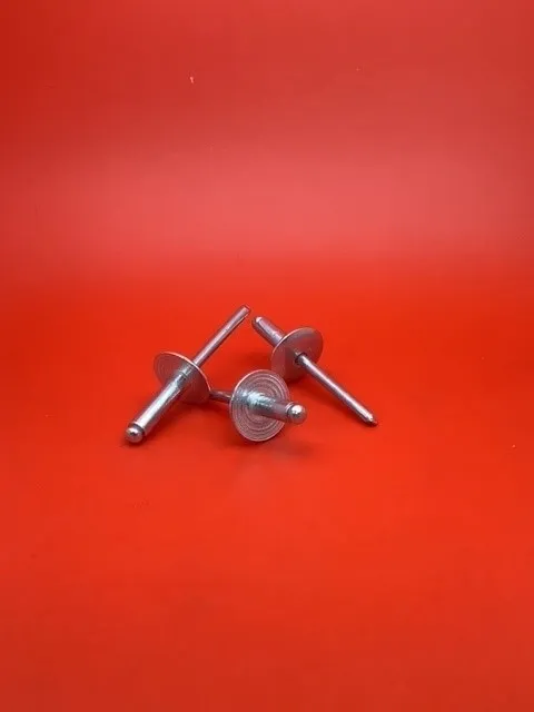 A pair of metal pins on top of a red surface.