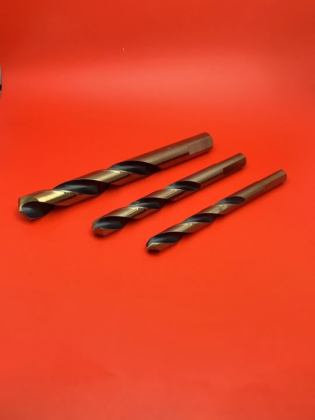 A set of drill bits on top of a red table.