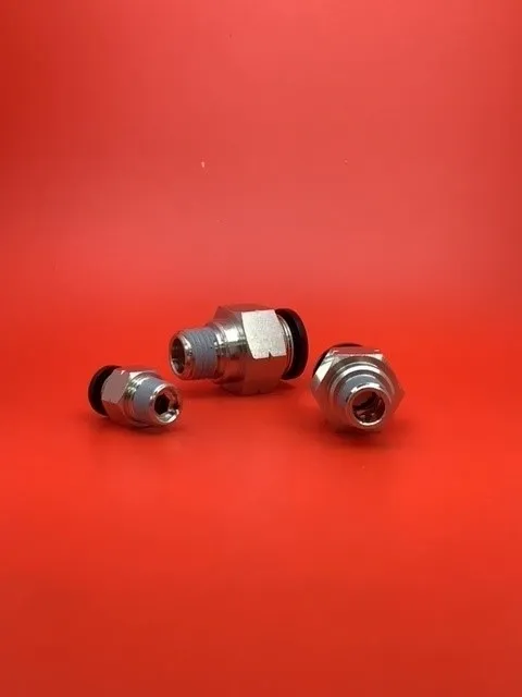 A group of three metal nuts sitting on top of a red table.