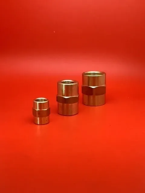 A group of three brass pipes sitting on top of a red table.