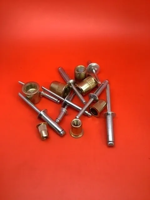 A bunch of nuts and bolts on top of a red table.