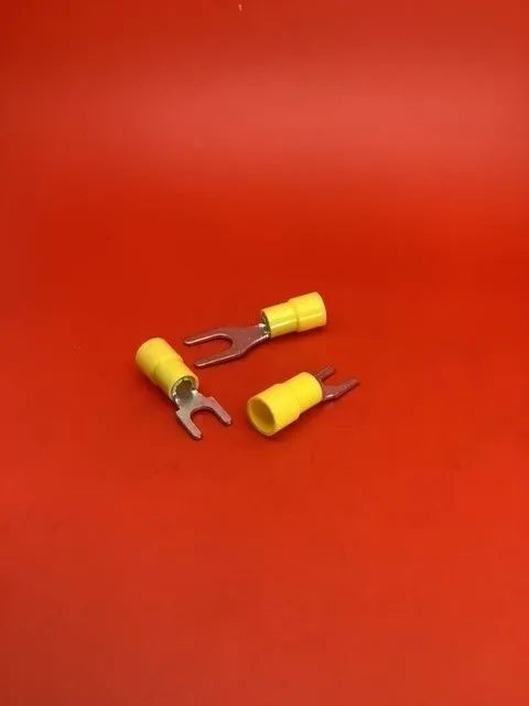 A pair of yellow electrical terminals sitting on top of a red table.