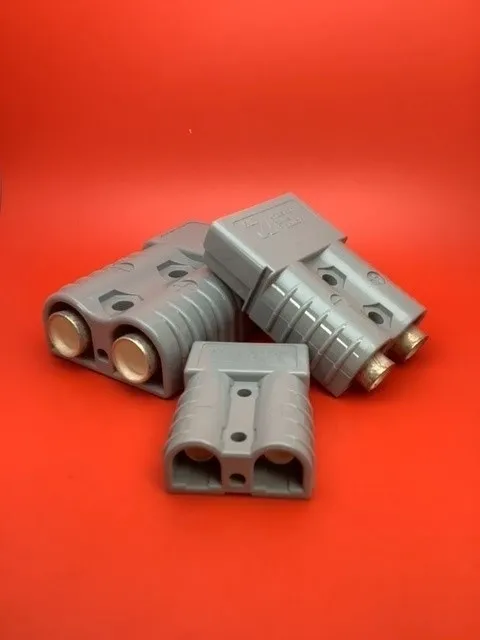 A group of four gray connectors sitting on top of a red table.