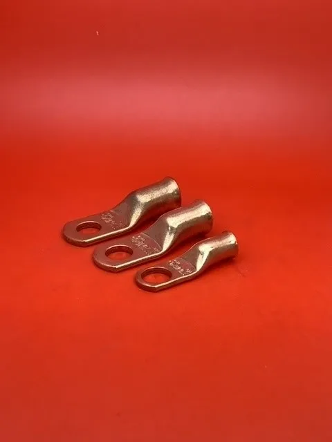 Three copper terminals sitting on top of a red table.