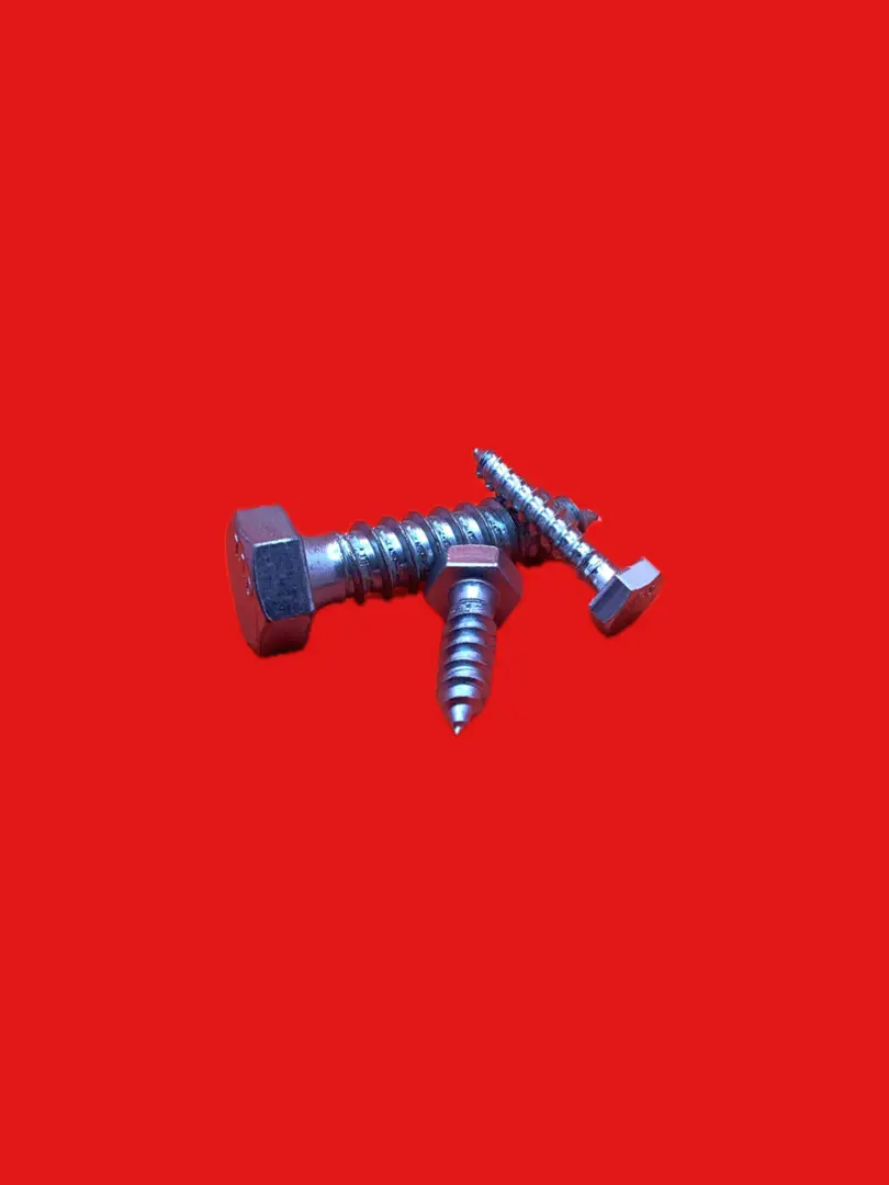 Three metallic screws on red background.